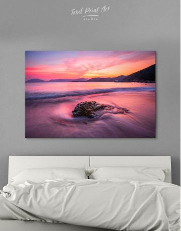 Rock in a Wavy Sea under an Orange and Pink Sky at Sunset Canvas Wall Art